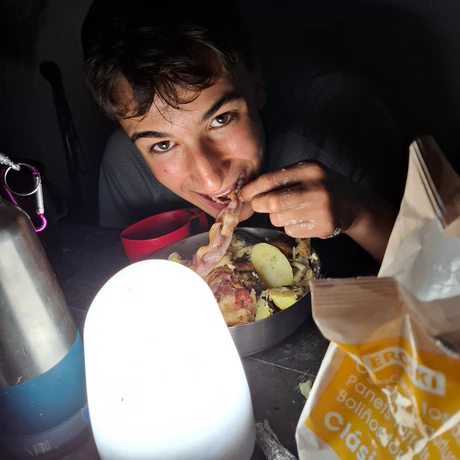 Scout cenando en acampada baco crujiente heco al fuego